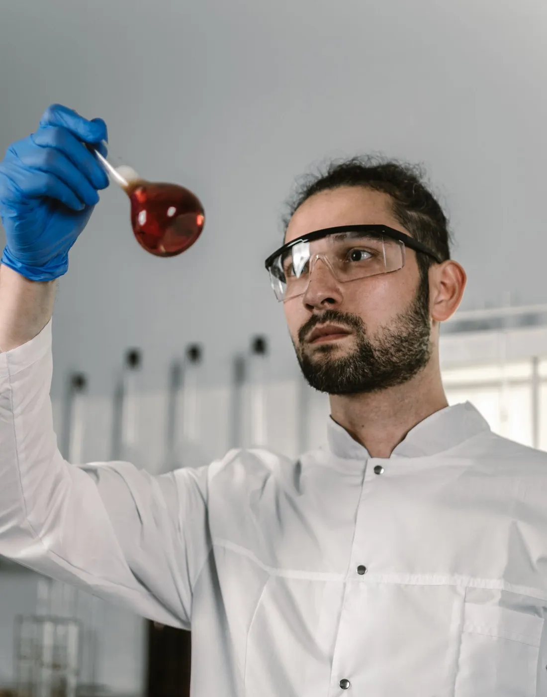 HelixaMed lab technician inspecting a sample flask during batch quality control